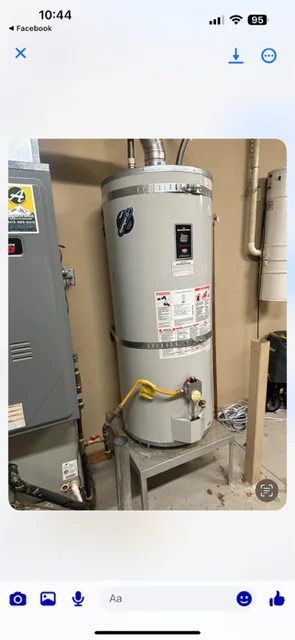 Newly installed white residential water heater with brass isolation valves and safety relief valve