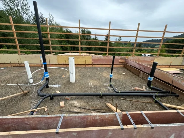 Irrigation system installation in equestrian arena with PVC lines and metal manifold